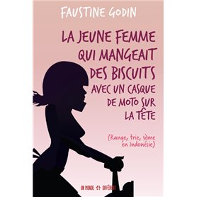 La jeune femme qui mangeait des biscuits avec un casque de moto sur la tête