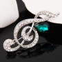 Broche Belons tendance en forme de note de musique/clé de sol avec strass et cristal vert en forme de goutte, pour femme
